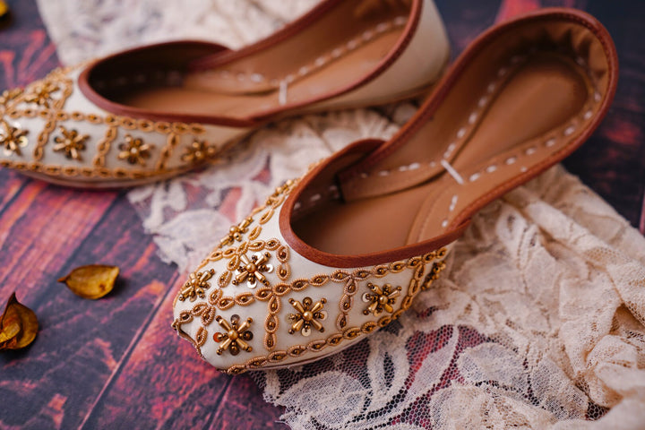 Ivory mojari for women featuring gold dabka/ French wire, gold beads and gold sequins embellishment