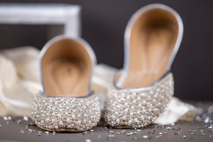 Silver khussa ladies shoes with pearl and rhinestones embellishment.