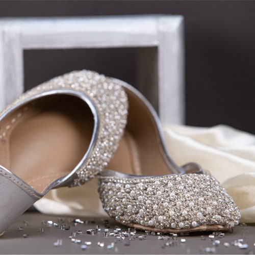 Silver traditional shoes of India with pearl and rhinestones embellishment.