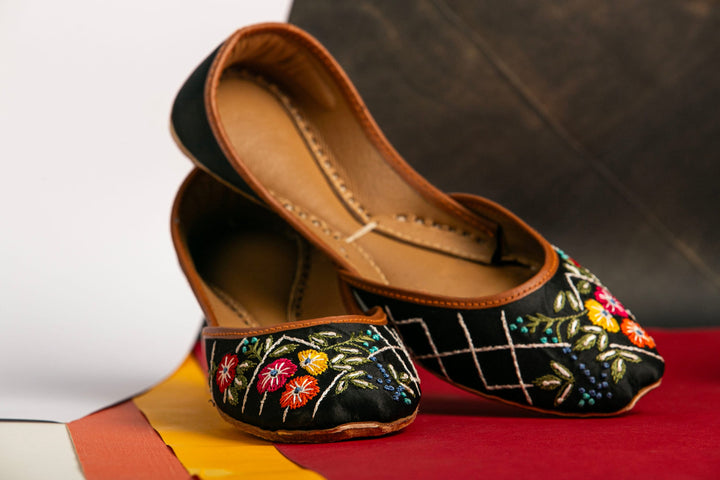 Black Indian mojri with red, yellow and orange flower embroidery.