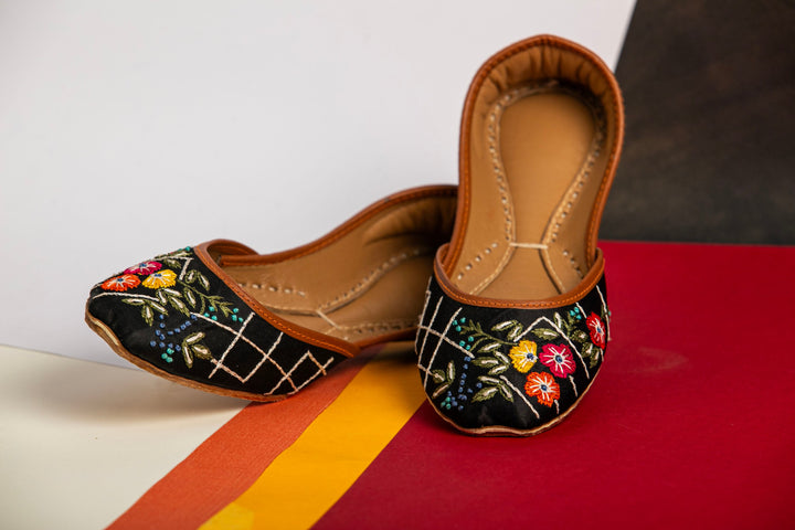 Black Pakistani Khussa with red, yellow and orange flower embroidery.