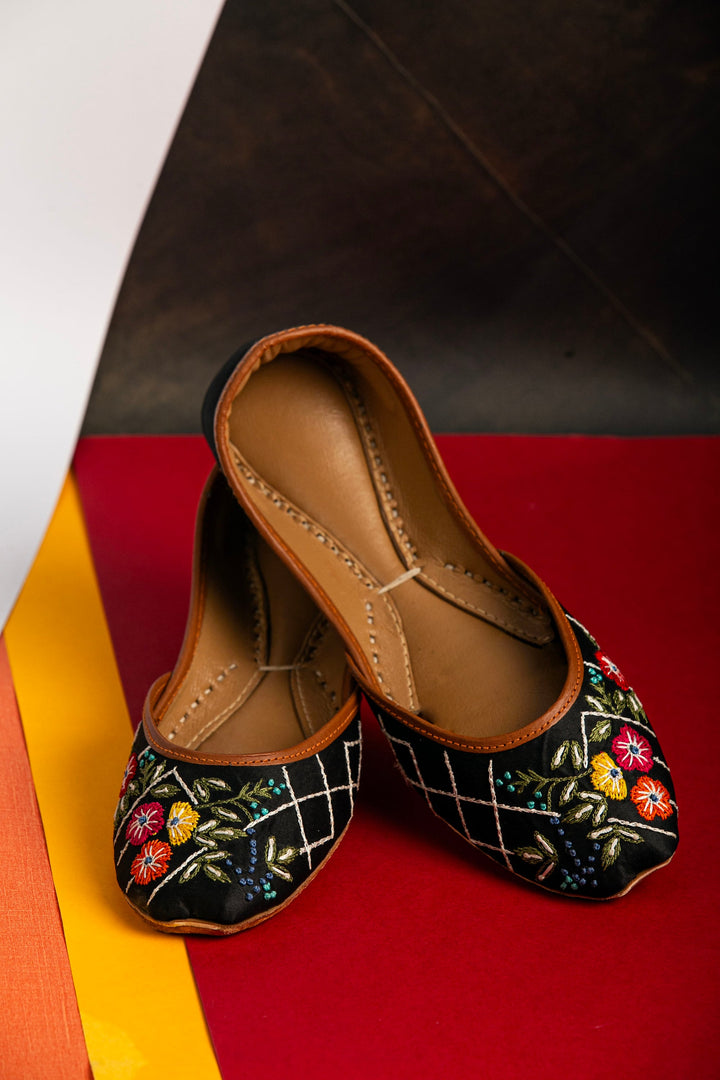 Black Indian ballet flats with red, yellow and orange flower embroidery.