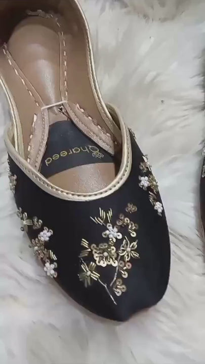 Product video of Traditional Impression black satin jutti flats showing the gold floral embellishment, light gold trim, insoles and flat construction.