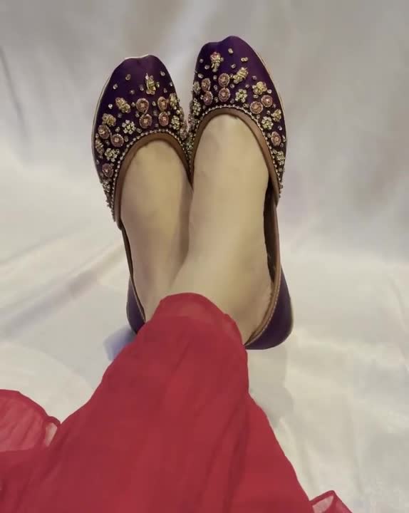 Watch purple floral-embroidered flats being worn, showing the decorated toes and traditional jutti silhouette.